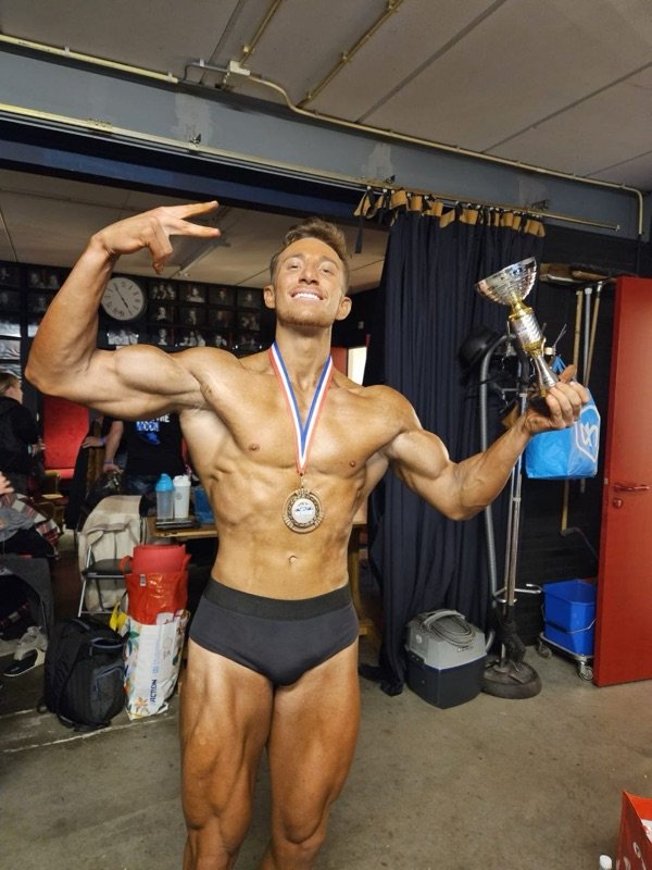 VS.Coaching-Athlet mit Medaille und Pokal nach dem Wettkampf